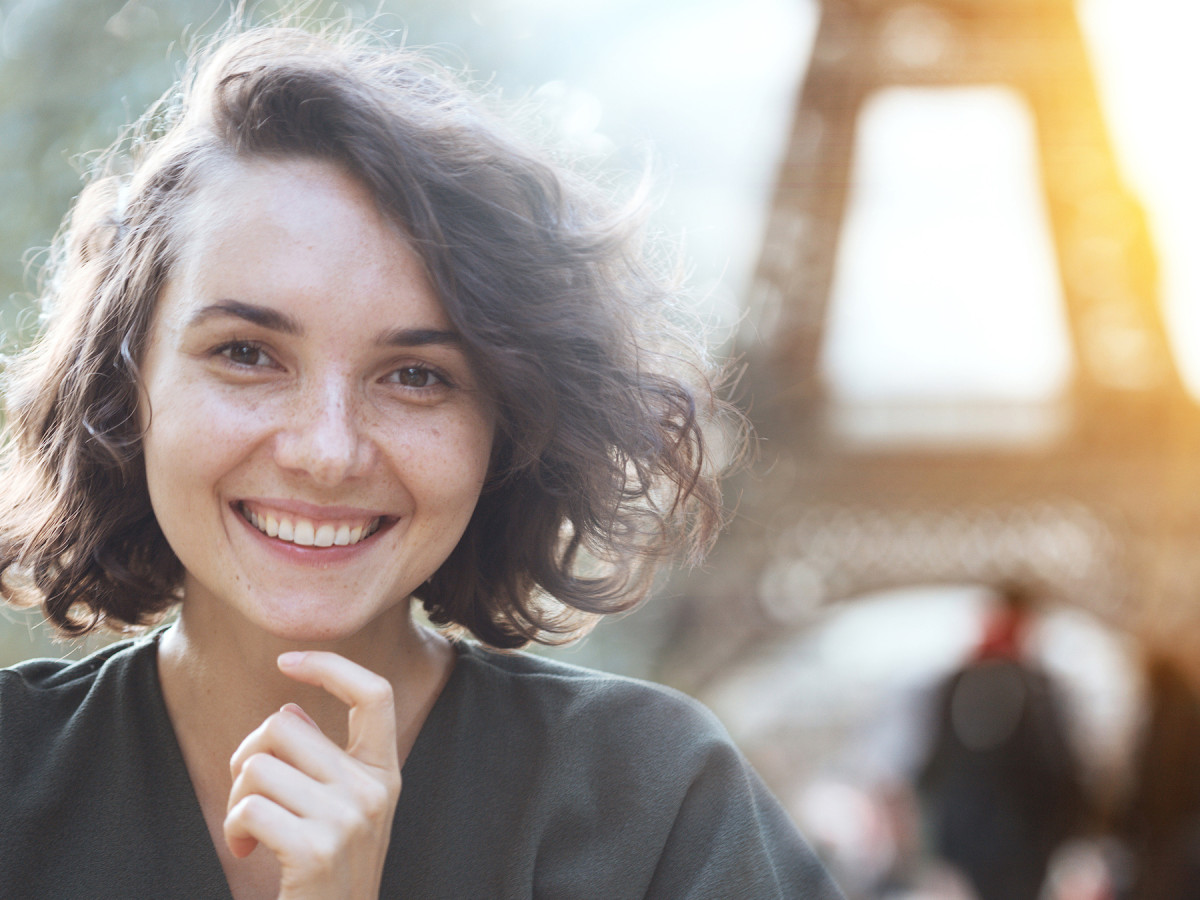 En ung kvinne i Paris med eiffeltårnet i bakgrunn